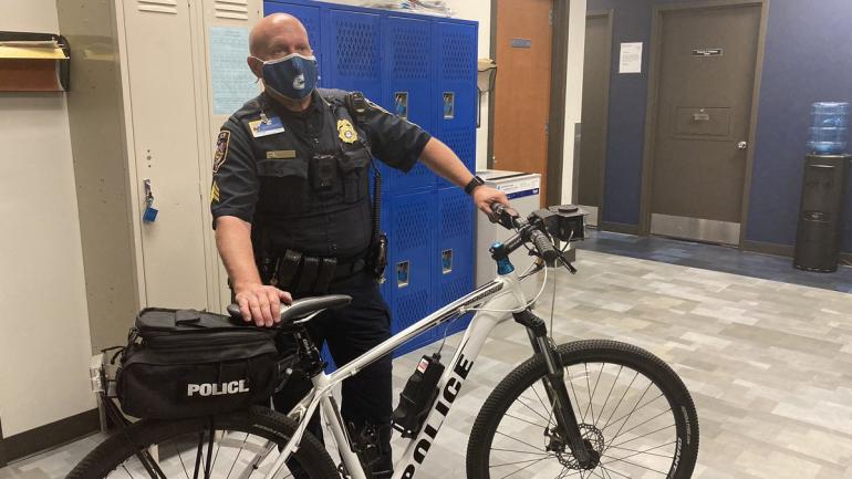 UTC Police Officer standing next to bike getting ready to patrol campus.