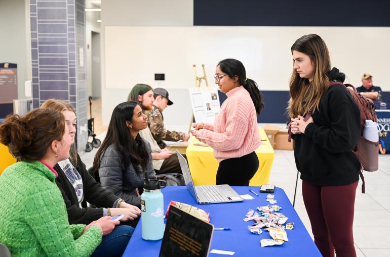 A student listening to another student at a table