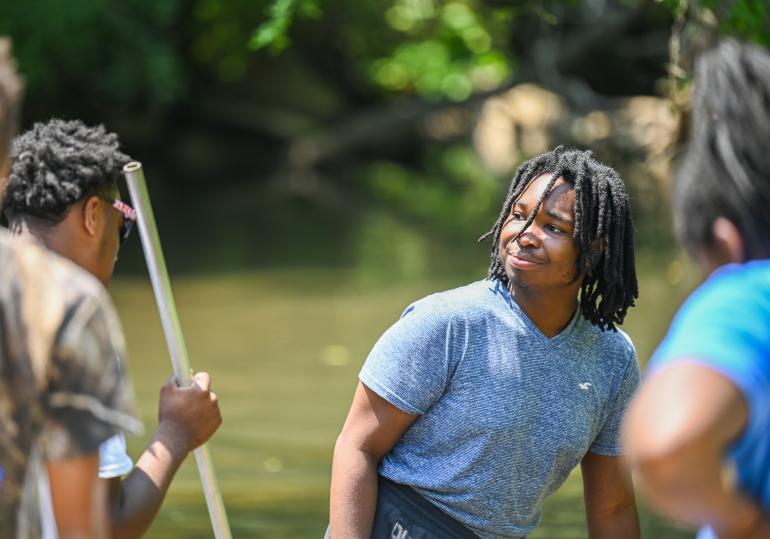 A boy smiling at man with stick