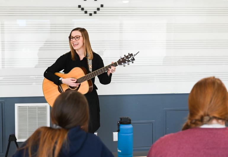 Photo of Katie Elverd playing guitar