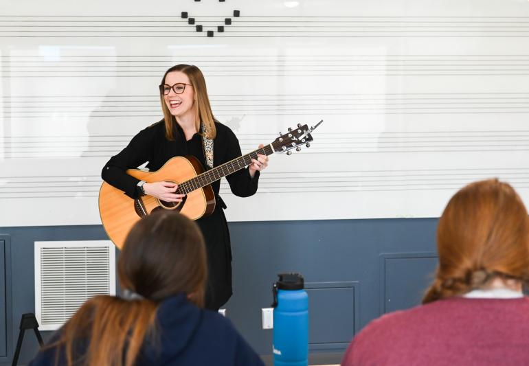 Introduction to Music Therapy Photo of Katie Elverd playing guitar