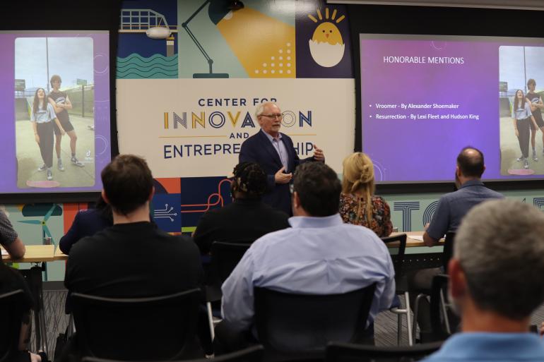 Mike Bradshaw, director of the UTC Center for Innovation and Entrepreneurship smiles as he introduces the contestants in the 2023 Fly Elevator Pitch Competition.