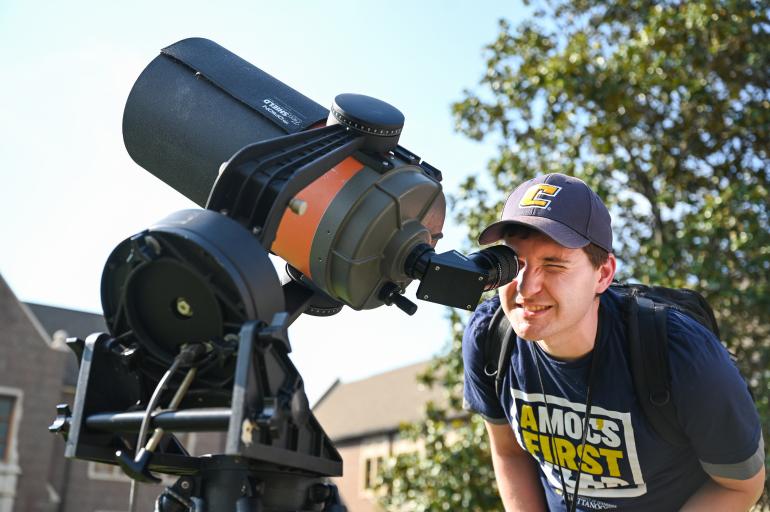 Student looking into a solar telescope pointed at the sky