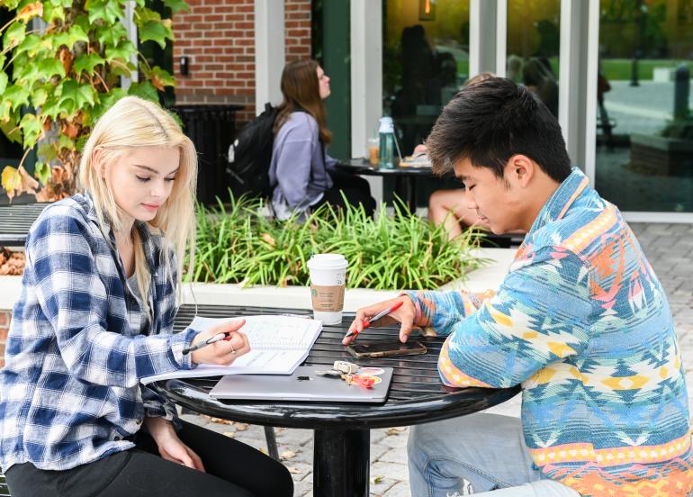 Two students studying outside of starbucks