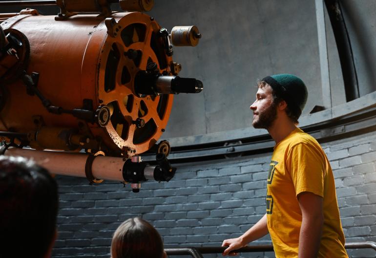 Student looking at a telescope 