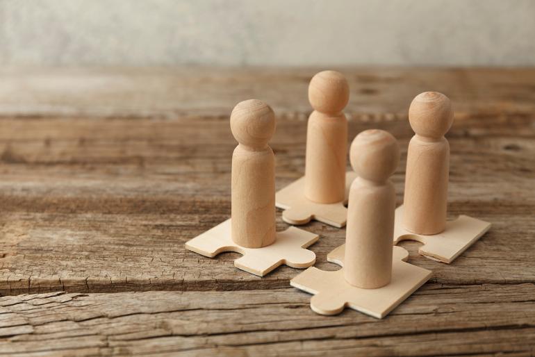Community and Connection Wooden block people on wooden puzzle pieces