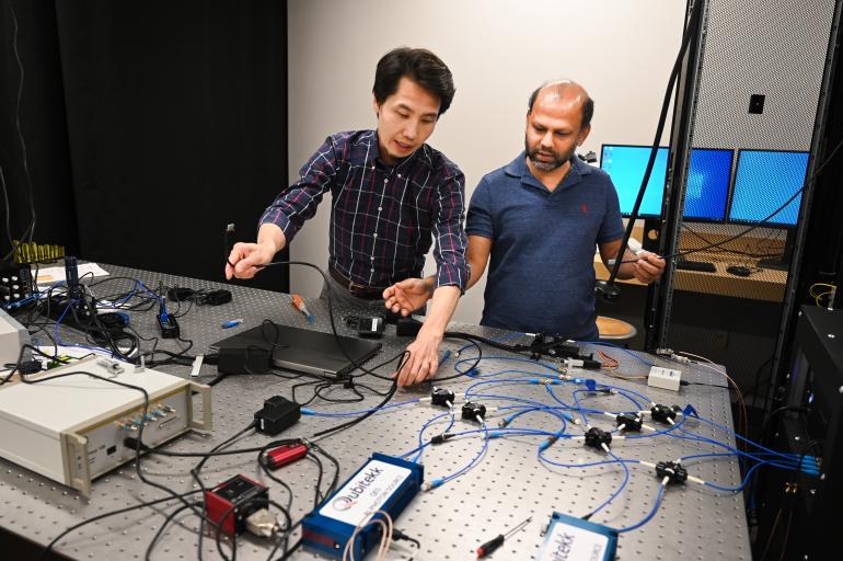Quantum Lab Tian Li working with grad student on quantum networking in the quantum lab.