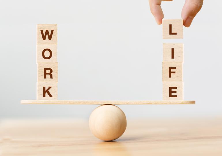Work life harmony wood blocks spelling work and life stacked on a wooden balance