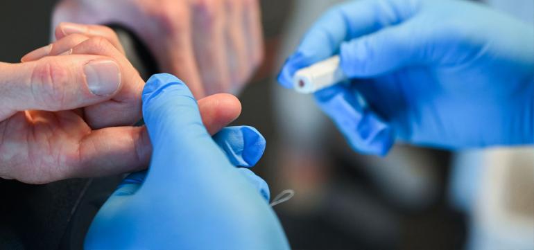HHP Sports Lab finger getting pricked.