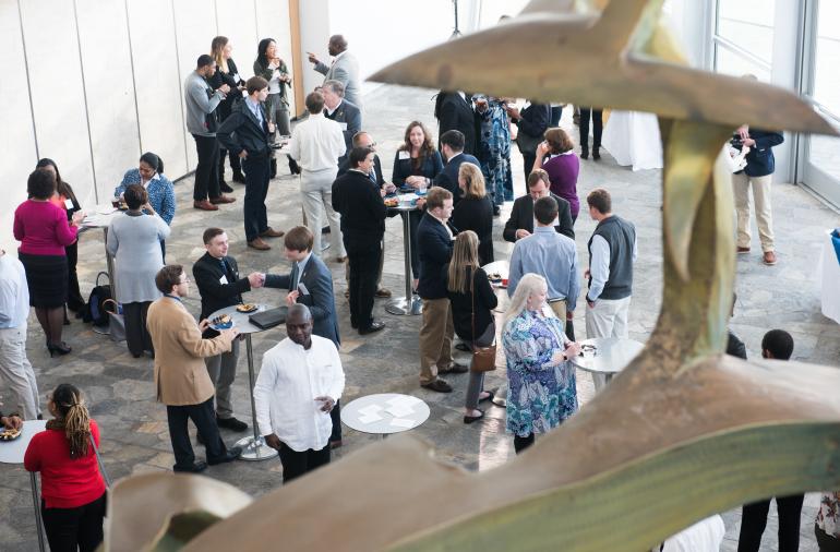 Students network with business professionals Tuesday, April 17, 2018 at the Hunter Museum of American Art. People at networking events chatting hanging out at circular tall tables.