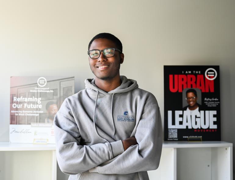 Tony Bonner intern at urban league Intern crossing arms at Urban League wearing Gray Rollins College of Business hoodie