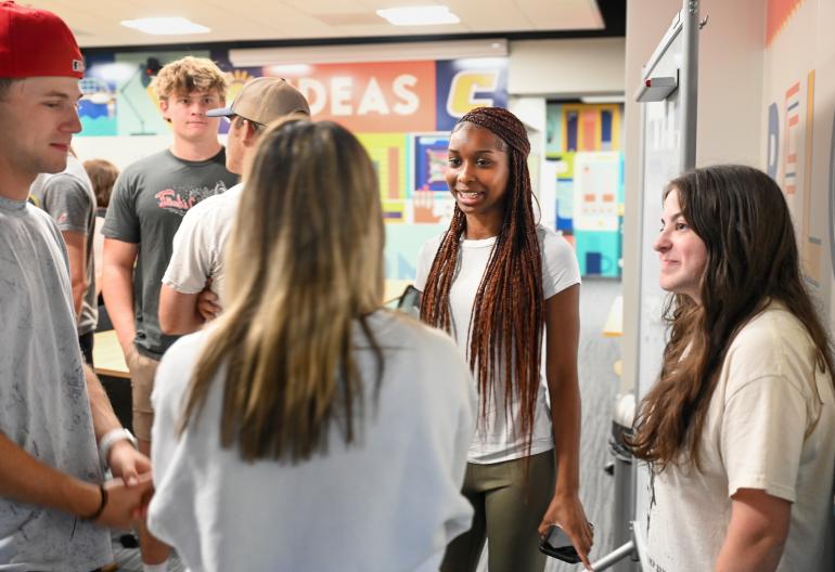 Students standing in circle having a converastion Students standing in circle having a converastion