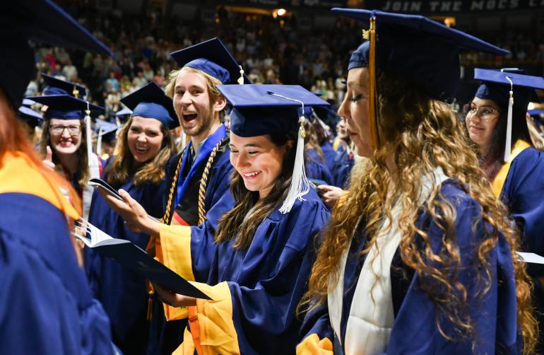UTC students smiling at a commencement ceremony 