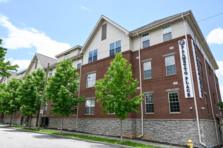 Three story building with Palmetto Place written down the corner of the building in attached letters