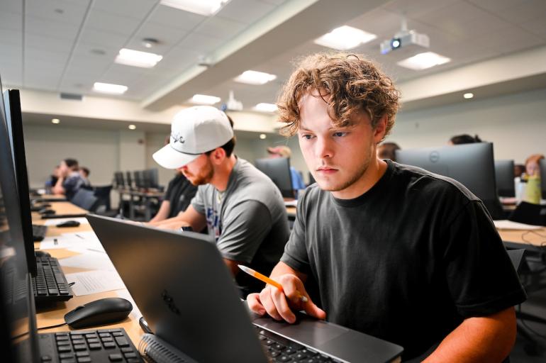 student on campus looking at computer