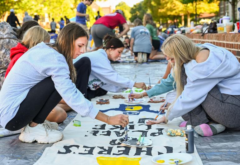 UTC students painting a banner