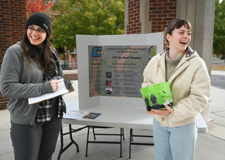 two UTC students standing in front of a research board