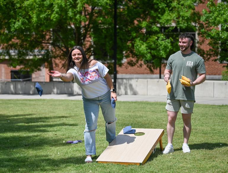 two UTC greek life students playing cornhole