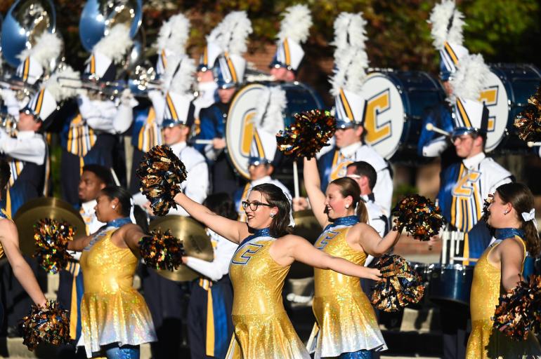 UTC cheerleaders and marching band members performing at a pep rally