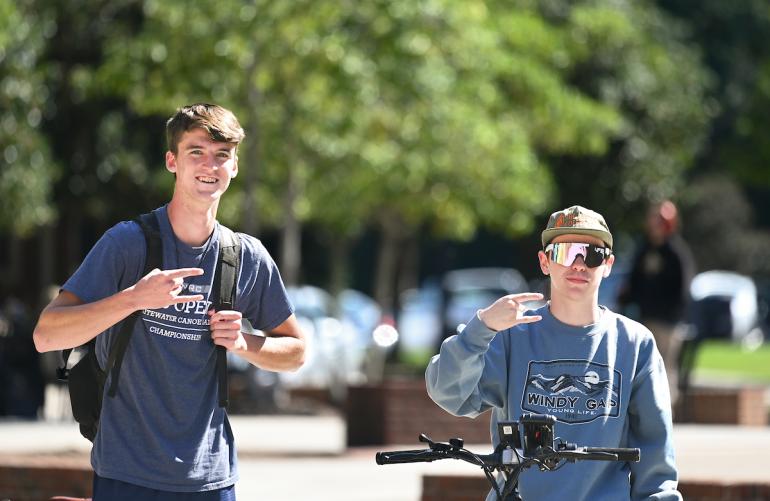 UTC students holding up the power C hand gesture