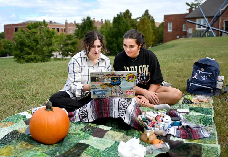 UTC students sitting on a blanket outdoors