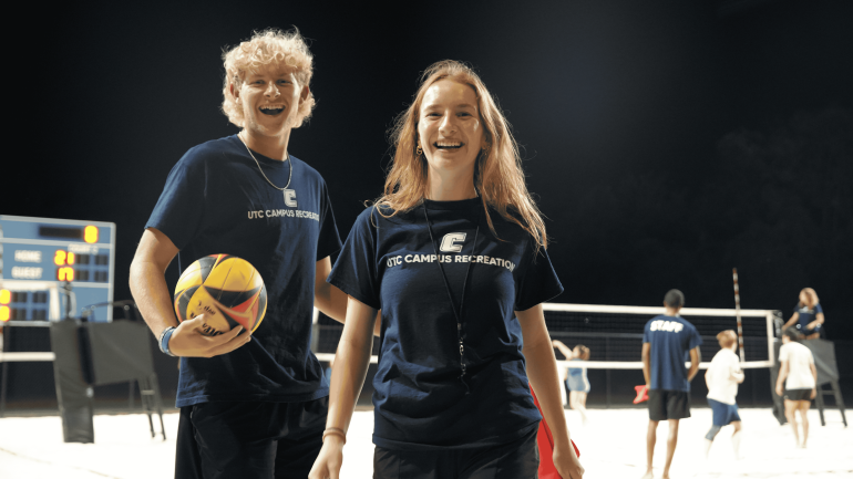 Man and woman playing sand volleyball.