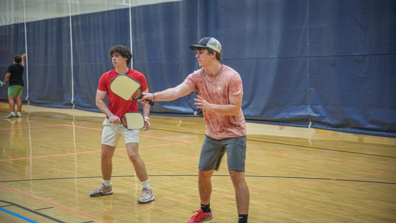 Two men playing picklebal.