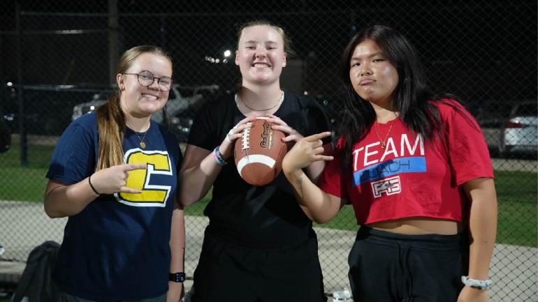 Picture of 3 students posing after playing flag football.