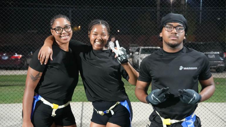 Picture of 3 students posing after playing flag football.