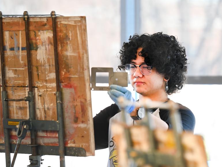 A student uses a viewfinder in Figure Painting class