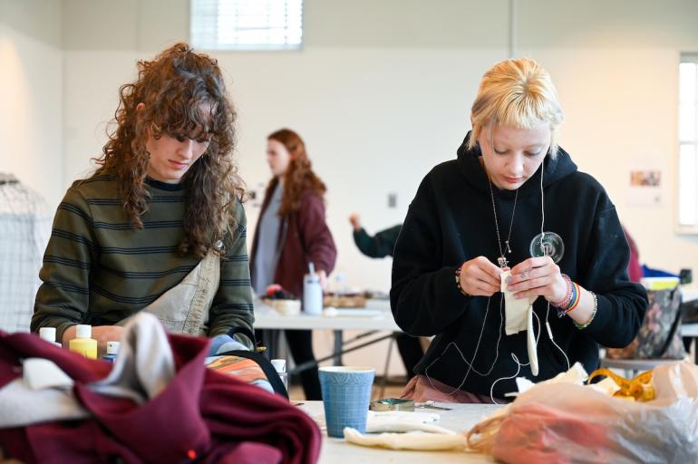 Students work side-by-side manipulating materials in Foundations course, Space and Sequence