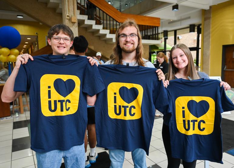 Students holding "I heart UTC" shirts