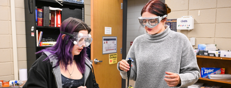 Two students performing a chemistry experiment