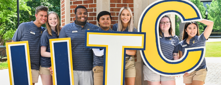 UTC orientation leaders pose holding UTC letters. 