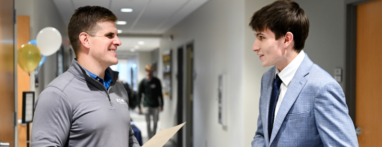 Student talking to an employer at a career fair. 