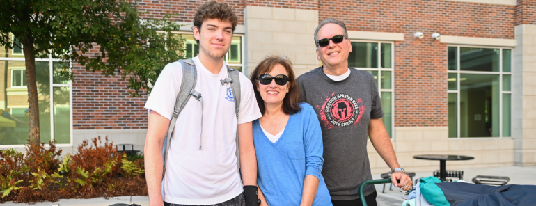 Parents and student pose for photo during operation move-in