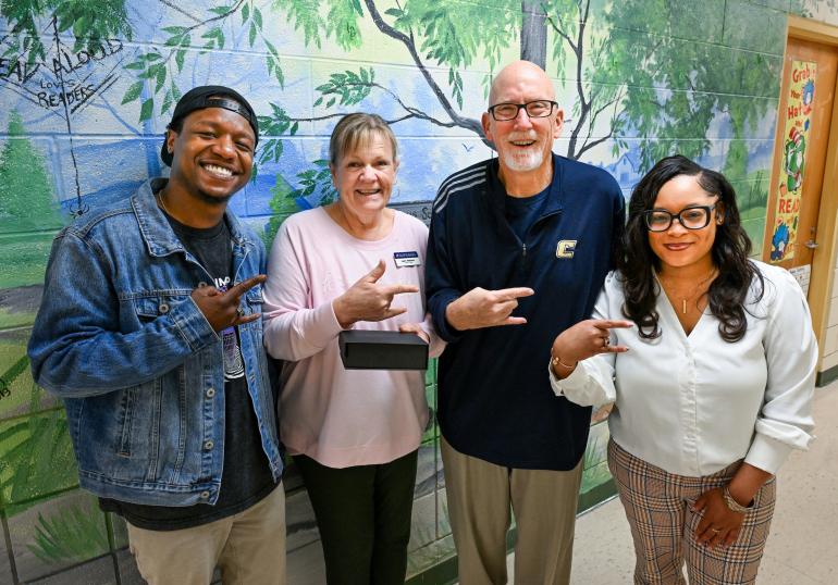 Moc’s Golden Feather Award winner Jean Walston (pink top) is joined by Children’s Center Coordinator Regis Richard, Provost Jerold Hale and Children’s Center Coordinator Jameshia Borders at Battle Academy. Photo by Angela Foster.