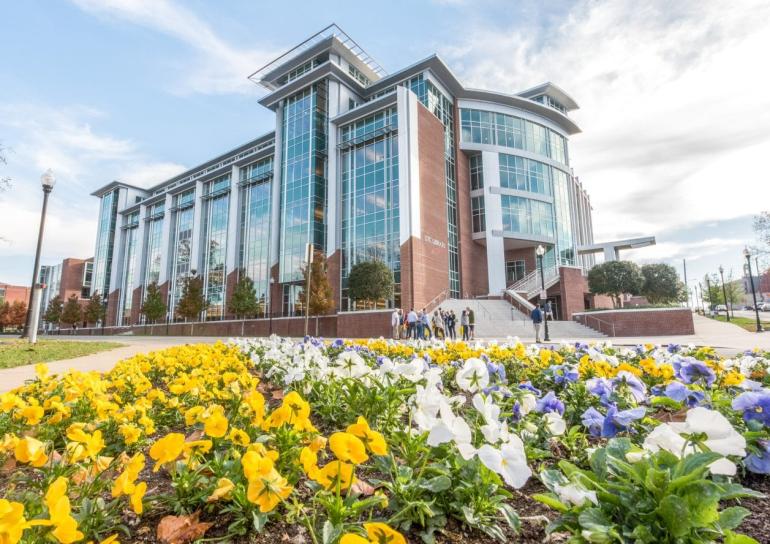 UTC Library outside with Blue, Yellow, and White flowers