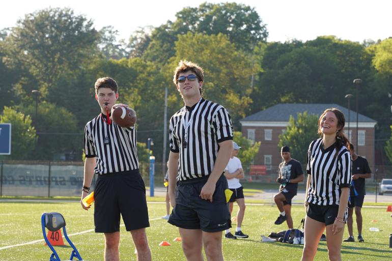 Young people officiating a flag football game. 