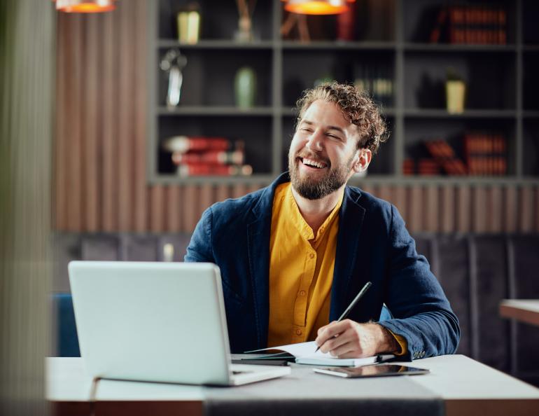 A professional man smiles in his office while using AI 