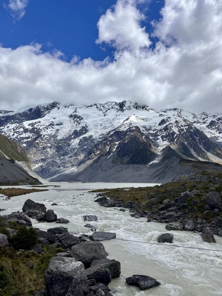 Glacial river flowing below snow-capped mountains in New Zealand