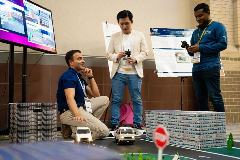 Photo showing a demonstration of the 1-tenth scale autonomous vehicle in a mini-scale city replica.