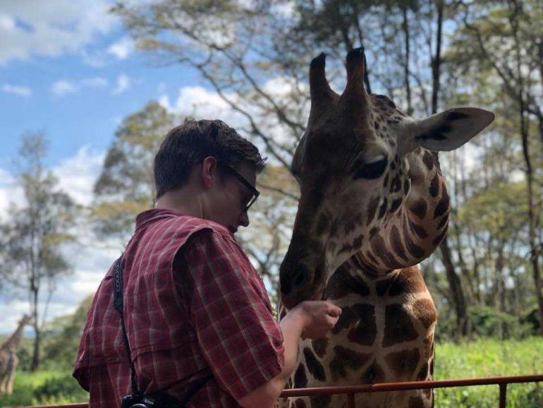 Man feeding a giraffe in Kenya