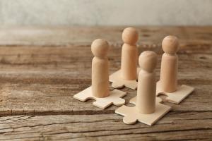 Community and Connection Wooden block people on wooden puzzle pieces