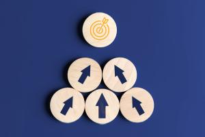Opportunities for growth five circular wooden blocks with arrows pointing to one circular wooden block with a target
