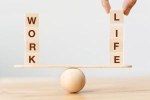 Work life harmony wood blocks spelling work and life stacked on a wooden balance