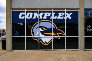 Esports Complex outside of esports complex with wrap featuring a headshot of scrappy