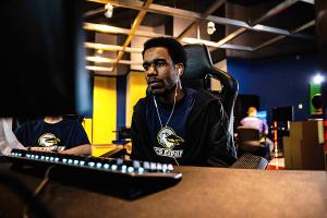 Esports team player UTC esports team player with esports tee on at a gaming console inside the esports complex