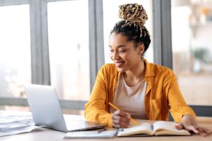 Student online MBA Student smiling while working on online assignment