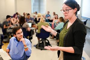 A UTC student talking to a panel of individuals at an event